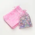 Roze organza zakjes met bloemen die de delicate print en de transparante netstructuur tonen - Roze