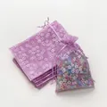 Detailweergave van paarse organza zakjes met bloemen gevuld met vrolijke gekleurde kralen - Paars