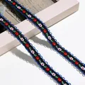 Detaillierte Nahaufnahme von ethnischem floralem Stickband mit blauer Wellenkante - 1m / Schwarz Weiß Rot