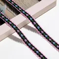 Detailaufnahme von schwarzem Blumen-Stickband mit rosa Wellenkanten - 1m / Schwarz/Rosa/Blau