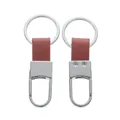 Vista anteriore e posteriore di eleganti portachiavi in pelle marrone e metallo lucido. - Circa 3*8cm / Argento & Rosso