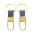 Vista dettagliata di due eleganti portachiavi in metallo dorato con cinturini in pelle grigia - Circa 3*8cm / Oro + Blu Chiaro