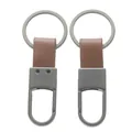 Detailed view of two gunmetal grey car keychains with brown leather strap texture - Approx. 3*8cm / Matte Gunmetal + Coffee