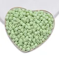 Perline di vetro verde chiaro cilindriche in un piatto a cuore per creare gioielli - Verde chiaro