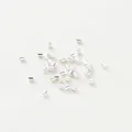 Close-up of small silver cylindrical spacer beads for handmade DIY jewelry making - 1.5mm Positioning Tube (Pack of 100) (GA0067) / Silver Tone Gold Plated