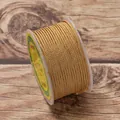 Close-up of golden 2.5mm braided jewelry cord wound on a spool for DIY crafts - Brown & Yellow