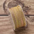 Detailed macro view of 2.5mm multi-color braided ruyi jewelry cord on a clear plastic spool. - Yellow/Blue/Pink
