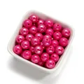 Gros plan de perles en acrylique fuchsia de 10 mm avec un fini nacré pour bijoux DIY. - 30 Pcs/Paquet / Rose rouge