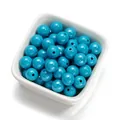 Gros plan de perles acryliques cyan de 10mm avec finition brillante dans un bol blanc - 30 Pcs/Paquet / Bleu lac