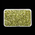 Macro view of metallic gold irregular crushed glass for nail art in a storage box - Metallic Green
