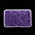 Close-up detail of high-shine irregular purple glass crushed stones in a clear box - Light Blue