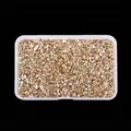 Detailed view of irregular golden high-bright glass crushed stones in a plastic box - Champagne
