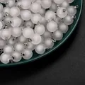 Close-up view of frosted white acrylic round bead charms with silver loops - Round / 5 Pieces/Pack / White