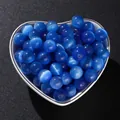 Makro-Detailansicht lebhafter blauer Katzenaugen-Steinperlen in einer herzförmigen Schale. - Runde Perlen / 20 Stück (6mm) / Blaues Katzenauge