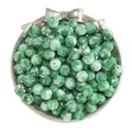 Detailed view of green marble pattern acrylic loose beads in a decorative tray - Pack of 50 (10mm / Hole 1.5mm) / Snowflake Deep Green White