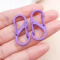 Nahaufnahme von zwei violetten S-Karabinern in einer Hand zur Bestimmung der Produktgröße - S-Förmiger Lackierter Doppelverschluss (FT200) / 1 Stück (33x14mm) / Lila