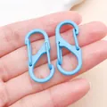 Vue détaillée de deux mousquetons en S bleu clair dans la main pour la création de bijoux - Fermoir Double Peint en S (FT200) / 1 Pièce (33x14mm) / Bleu