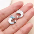 Dettaglio di ciondoli a forma di delfino iridescenti e argentati per la creazione di gioielli - Delfino Fantasia Marina (28150) / 1 Pezzo (15x12.5x4mm) / Blu