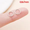 Gedetailleerde close-up van 0,8x7mm roestvrijstalen buigringen op vinger voor schaal - 0.8x7mm (1 Stuk)