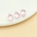 Set of three pink iridescent water drop glass beads on a white surface for DIY jewelry crafts - Small Straight Hole Teardrop Bead (23675)