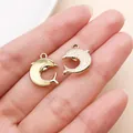 Detailed pair of gold-plated dolphin charms for DIY jewelry making shown on a palm - Gold Green Dolphin (28147)
