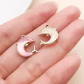 Gold and pink dolphin charms for DIY necklace and earring making displayed on a palm - Gold Pink Dolphin (28148)
