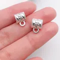 Close-up view of two silver-colored retro bail beads showing detailed embossed patterns. - Relief Texture (20676) / 1 Piece (11x8mm) / Bright Silver