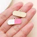 Macro view of pink and white pill-shaped enamel charms with heartbeat line pattern - Pink Drip Oil Pill (27894)