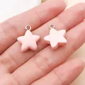 Close-up of small pink star resin charms held in a hand for size comparison - Star Shape (17160) / 1 Piece (14x16mm) / Pink