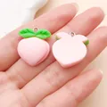 Detailweergave van twee schattige roze perzik-harsbedels op een hand voor schaal. - Perzik (24240) / 1 Stuk/Pak (20x22mm) / Roze