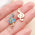 Detailopname van roségouden vioolsleutelhangers met blauw email en strasaccenten - Emaille Muzieknoot (11050) / 1 Stuk (9x21mm) / Meerblauw