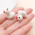 Cute pair of white goose resin charms shown on a palm for DIY keychain and bag accessories - White Resin Small Duck (17218) / 1 Piece (17x19mm) / White