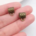 Two vintage bronze patterned charm bail spacers shown on fingers for scale - Vintage Relief Bail (20667) / 1 Piece (11x8mm) / Antique Bronze