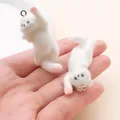 Detalle de primer plano de dos pequeños dijes de gatitos blancos para manualidades - Gato estirándose (27484) / 1 unidad (44x18x19mm) / Blanco