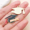 Detailed macro view of alloy graduation cap charms with student text and red tassel accents - Orange STUDENT Cap (27459)