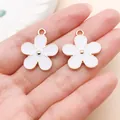 Gedetailleerde weergave van twee witte kersenbloesem emaille hangers op een hand - Grote Dubbelzijdige Witte Druppelolie Bloem (27581)