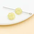 Primer plano de una cuenta de vidrio amarilla de 10 mm enhebrada en un alfiler de metal. - Amarillo gelatina