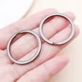 Close-up of 30mm gunmetal grey circular split rings held in a hand for DIY crafts - 30x30mm / Gunmetal