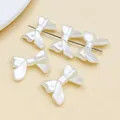 Nahaufnahme von cremeweißen Schleifenperlen mit Perlmuttglanz für DIY-Schmuck. - 1 Stück Packung (15x20mm)