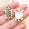 Detailed close-up showing front and back of gold turtle charms with rhinestones for DIY jewelry - Black Enamel Rhinestone Ocean Turtle (27057) / 1 Piece/Pack (29x17mm) / Gold