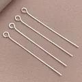 Cuatro alfileres de ojo plateados para joyería DIY sobre un fondo de tela marrón texturizada - Alfiler de ojo (T81)