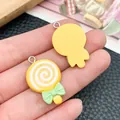 Close-up of colorful lollipop resin charms with bow ties for DIY jewelry making. - Yellow
