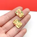 Detailed macro view of two lucky cat sand gold charms on fingers for DIY jewelry. - 1 Piece (19x12mm)