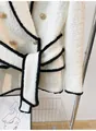 Detailed view of luxury white tweed jacket with gold lion buttons and black fringe trim - S / Tops / White