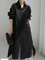 Vista detallada de un vestido camisero oversize de algodón y lino negro con aberturas laterales - S / Negro