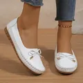 Detaillierte Nahaufnahme weißer Damen-Loafers mit einer dekorativen Schleife auf Holzboden - 36 / Weiß