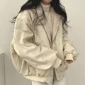 Detail van een crème oversized dubbelzijdige lamswollen jas met warme fleece voering. - S / Tops / Beige