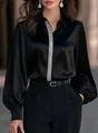 Detailed macro view of black satin blouse featuring lantern sleeves and silver glitter stripe - S / Tops / Black
