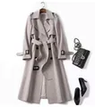 Dettaglio ravvicinato di un classico trench lungo doppiopetto con cintura e fibbie eleganti - Grigio chiaro