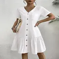 Detalle de un vestido blanco de algodón y lino con botones, cuello en V y bajo volante. - S / Vestidos / Blanco